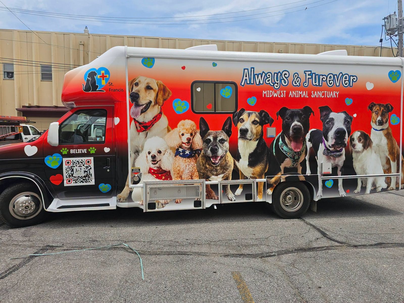 The full Always & Furever mobile veterinary clinic showing its red animal-themed exterior